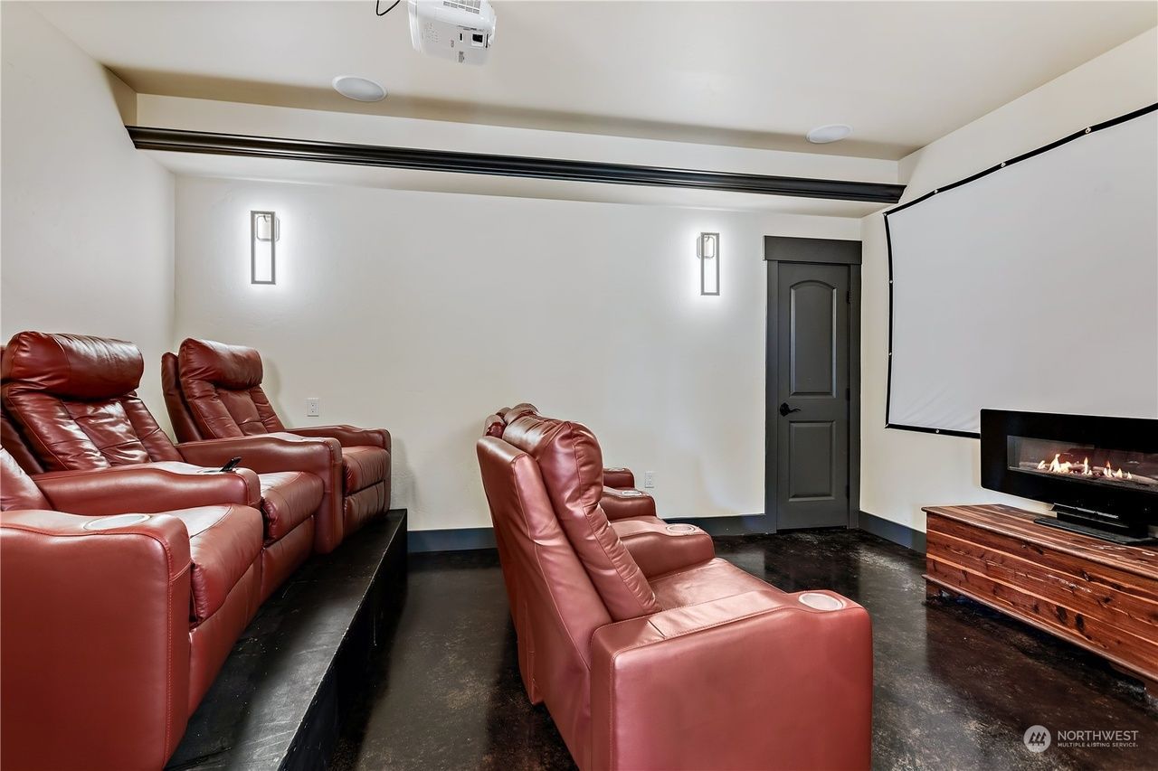 A home theater with red leather chairs and a projector screen.