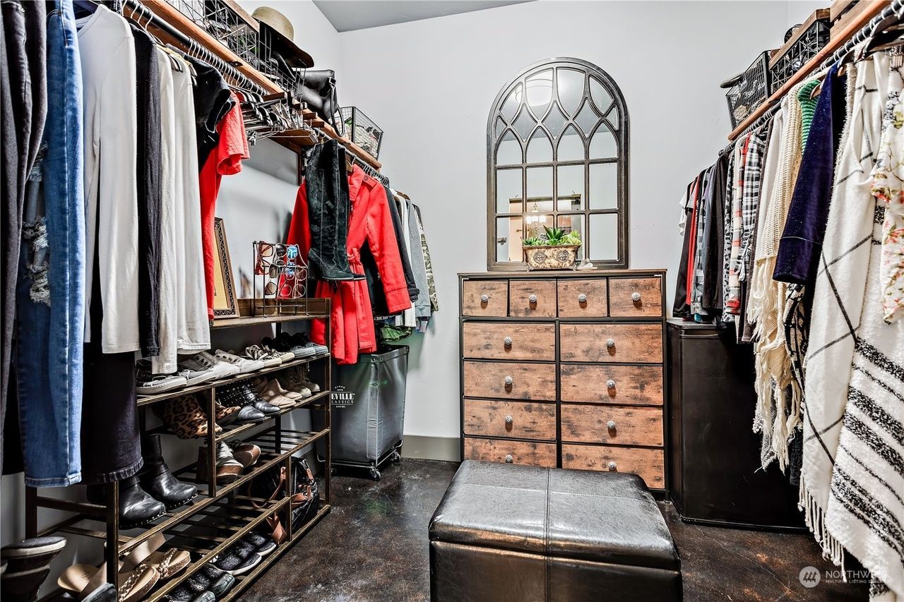 A walk in closet filled with lots of clothes and shoes.