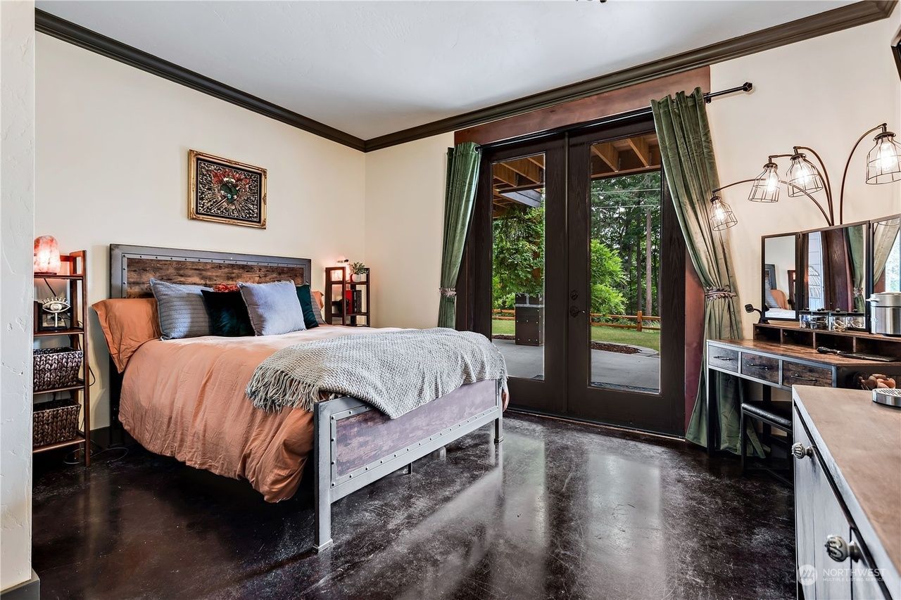 A bedroom with a bed, dresser, mirror, and sliding glass doors.