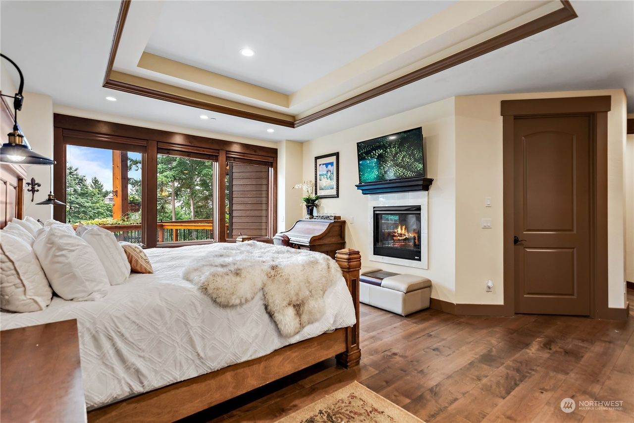 A bedroom with a king size bed and a fireplace.