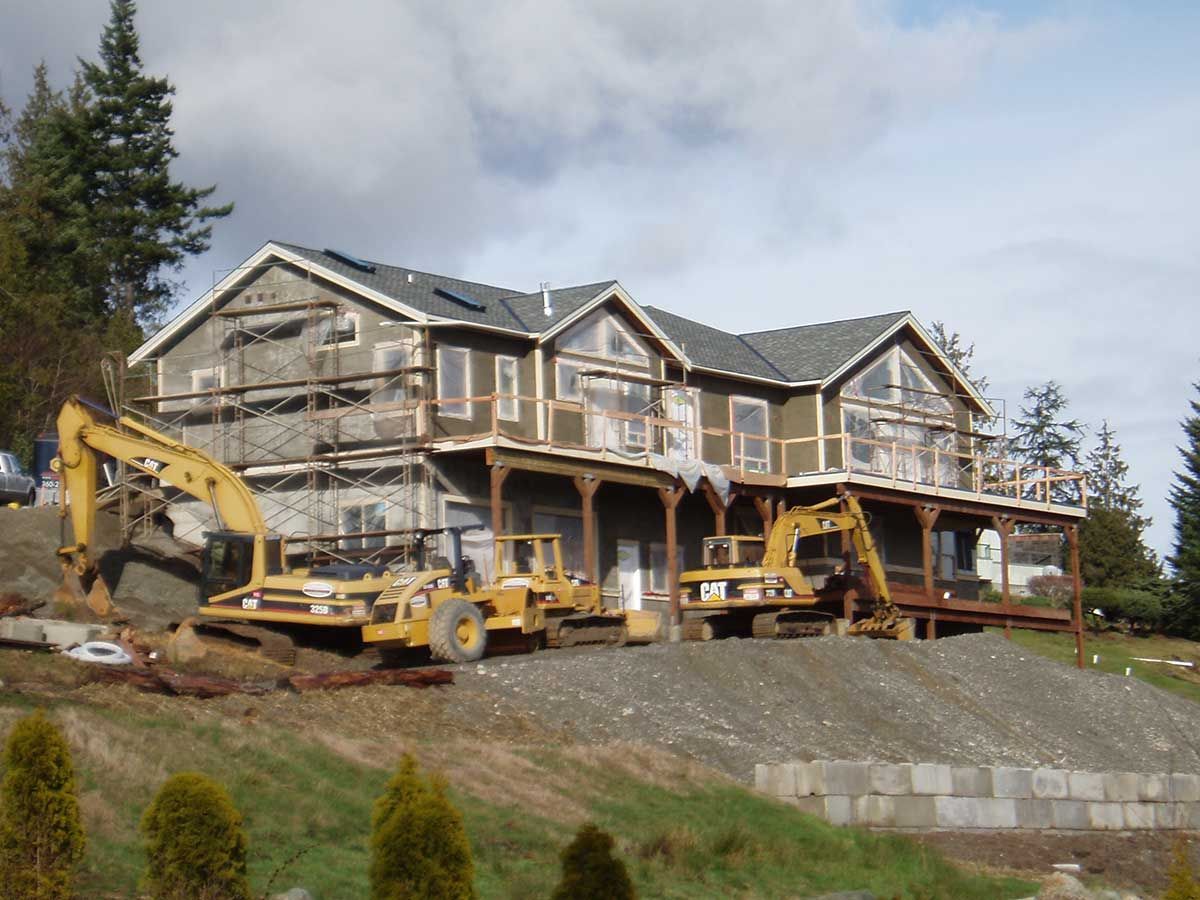 A large house is being built with a lot of machinery in front of it
