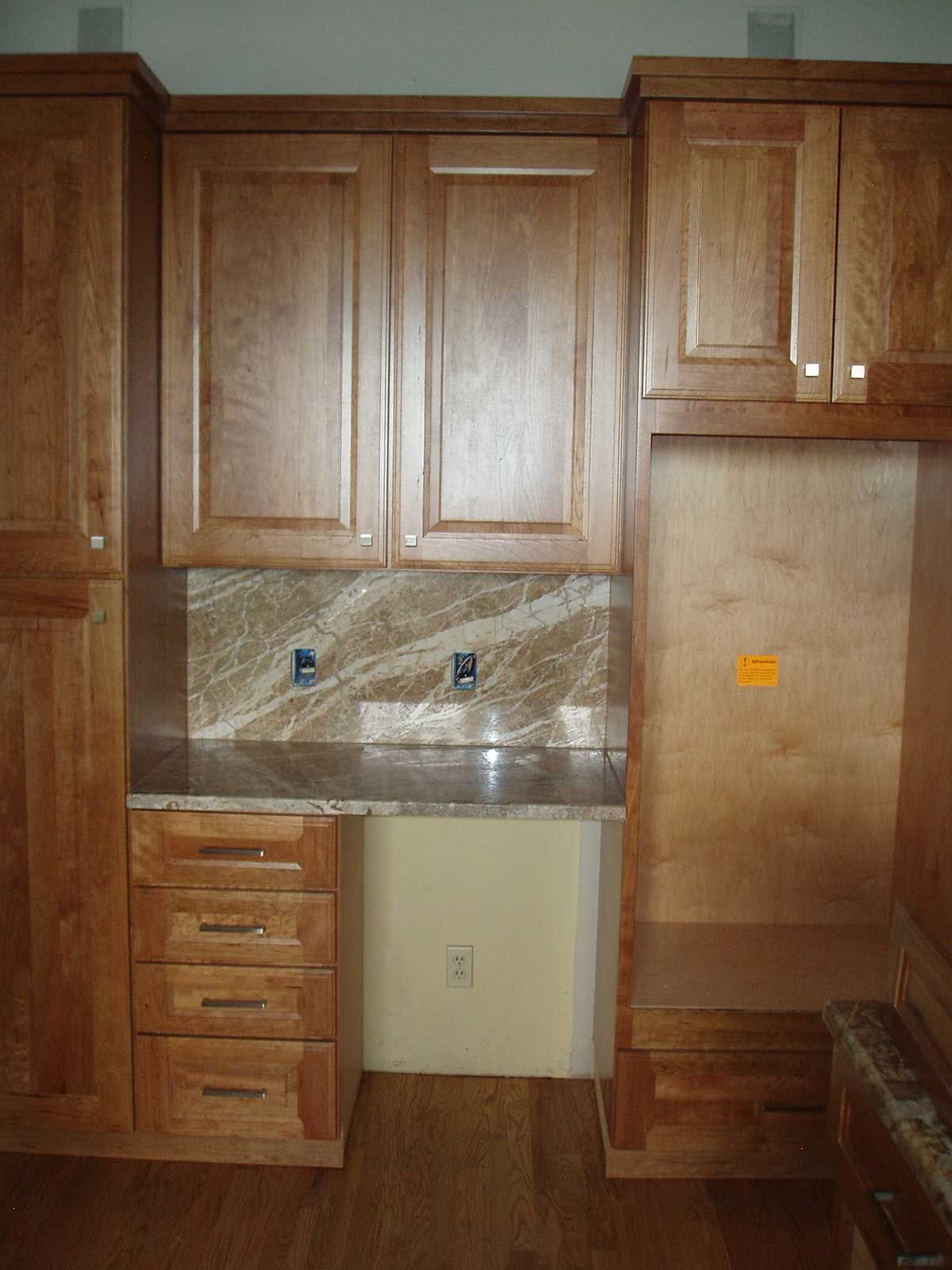 A kitchen with wooden cabinets and granite counter tops