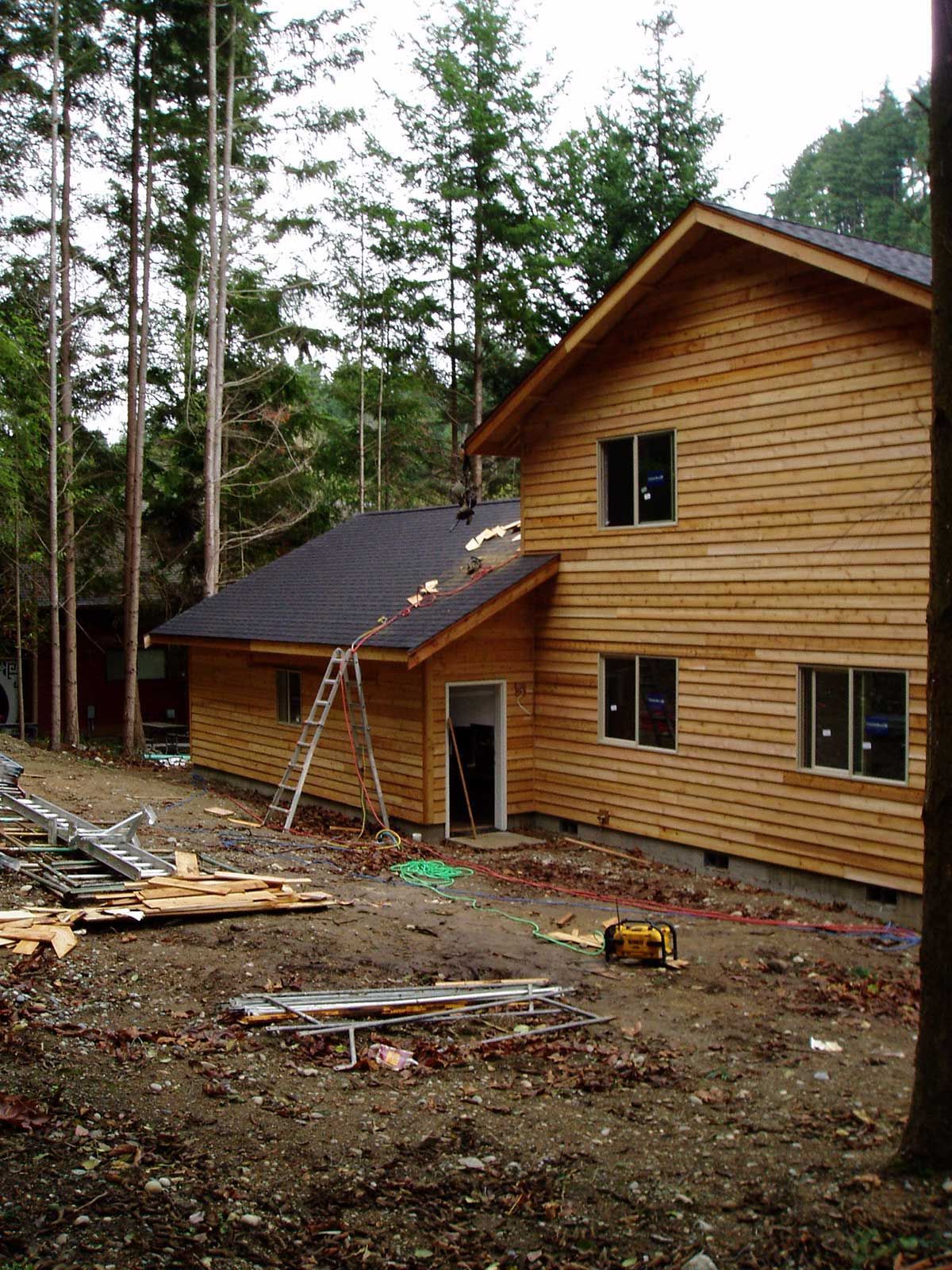 A wooden house is being built in the middle of a forest