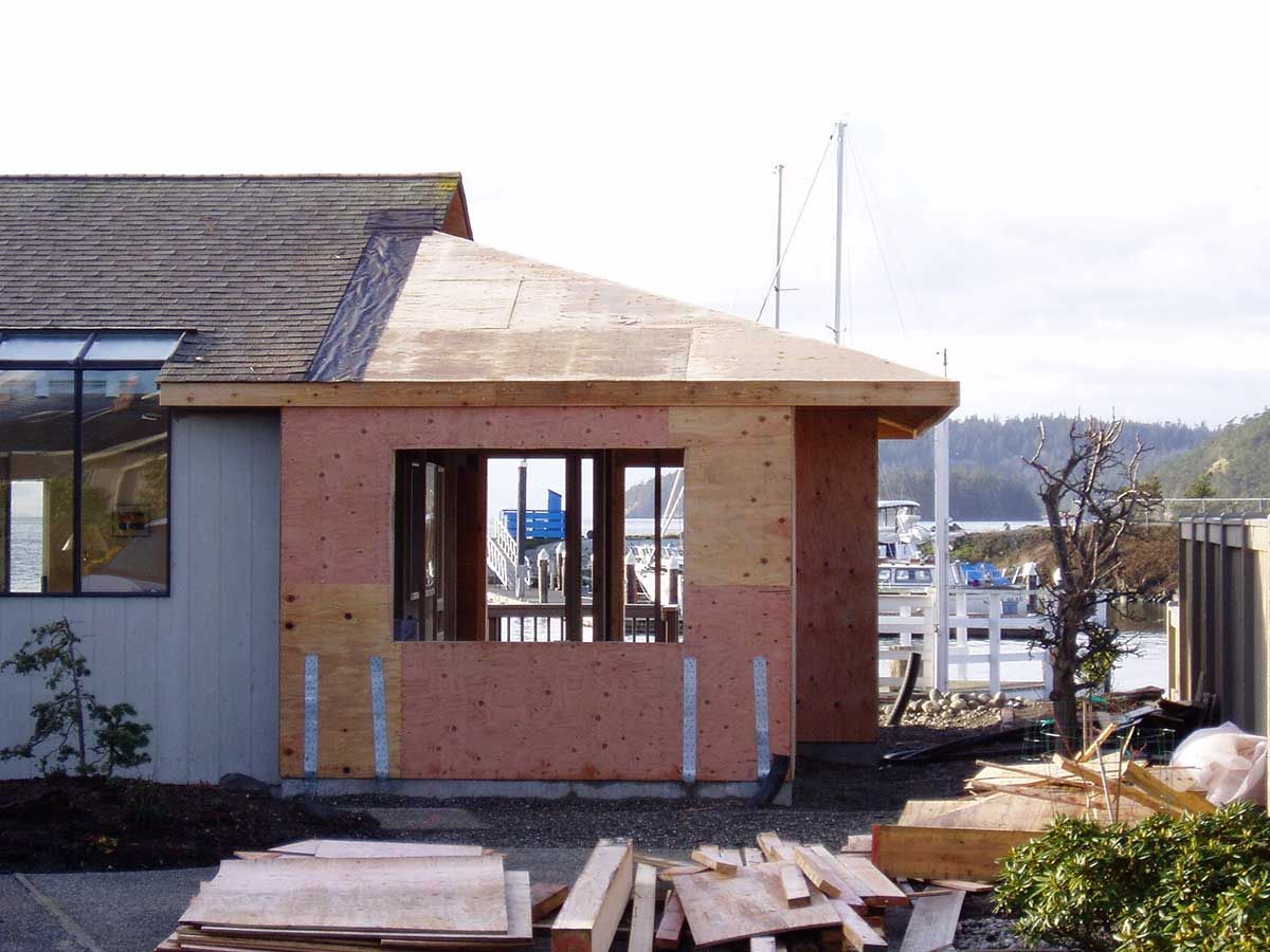A house that is being built with a lot of wood in front of it