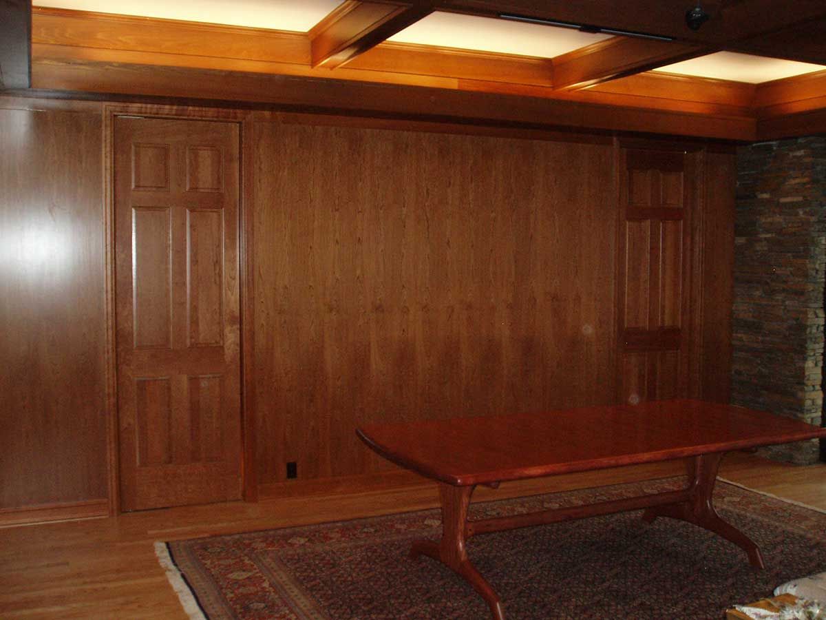 A living room with wood paneling and a table