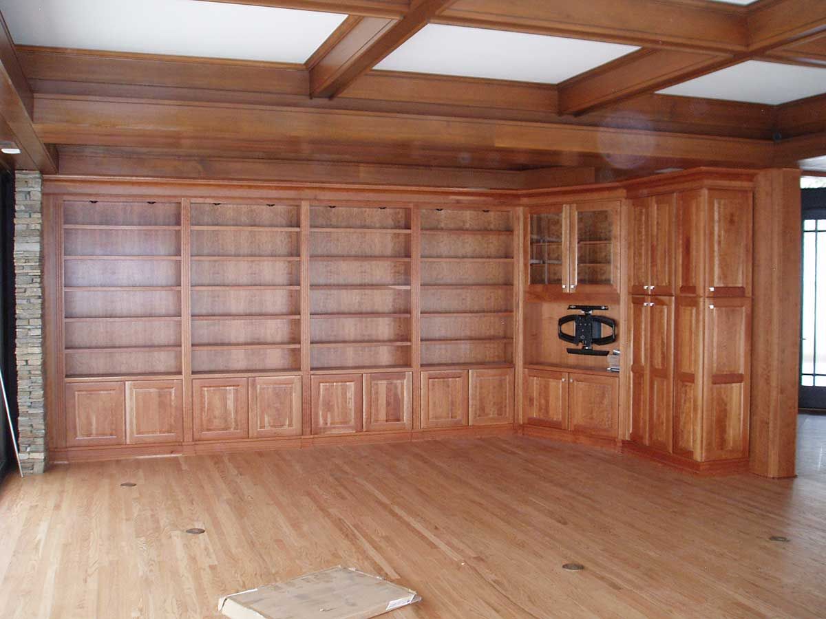 An empty room with lots of wooden cabinets and shelves