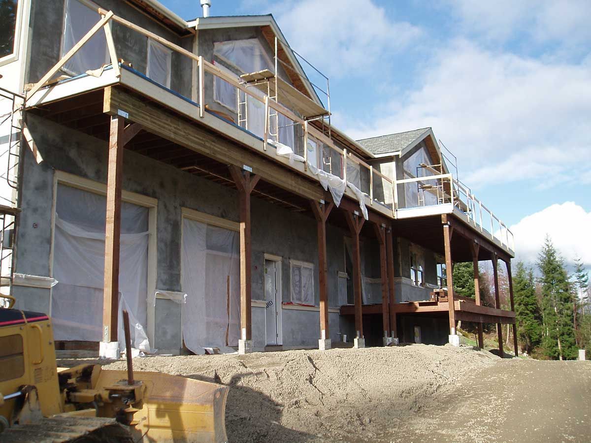 A large house under construction with a bulldozer in front of it