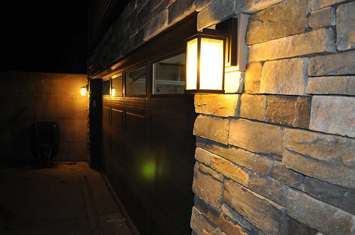 A garage door with a light on the side of it at night.