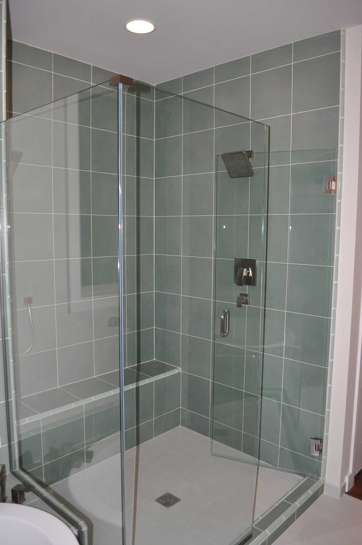 A bathroom with a walk in shower with a glass door.