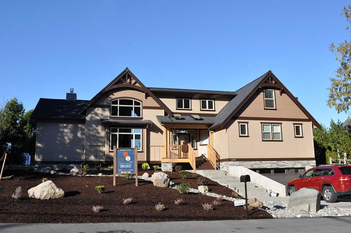 A large house with a for sale sign in front of it