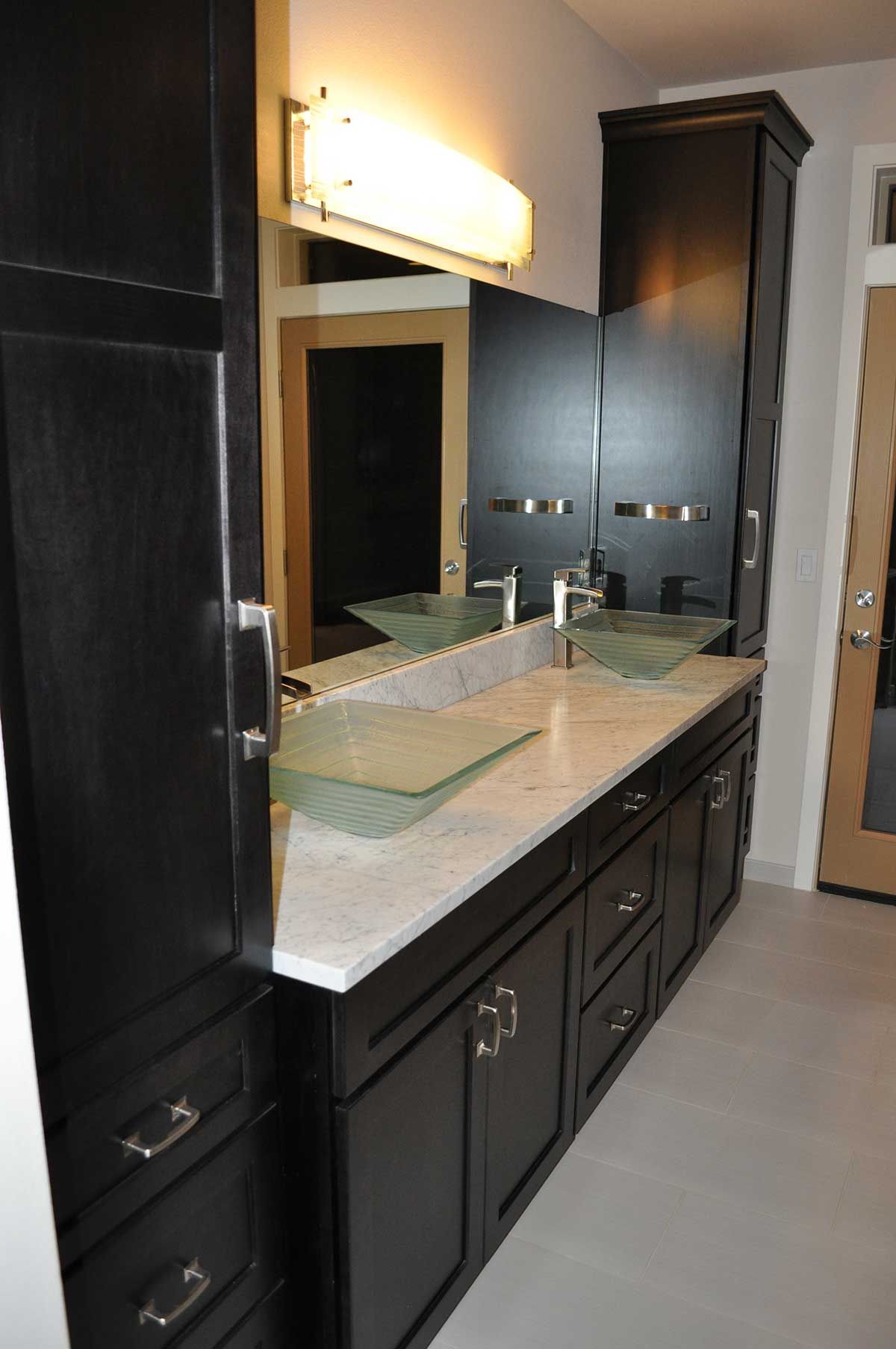 A bathroom with two sinks and a large mirror