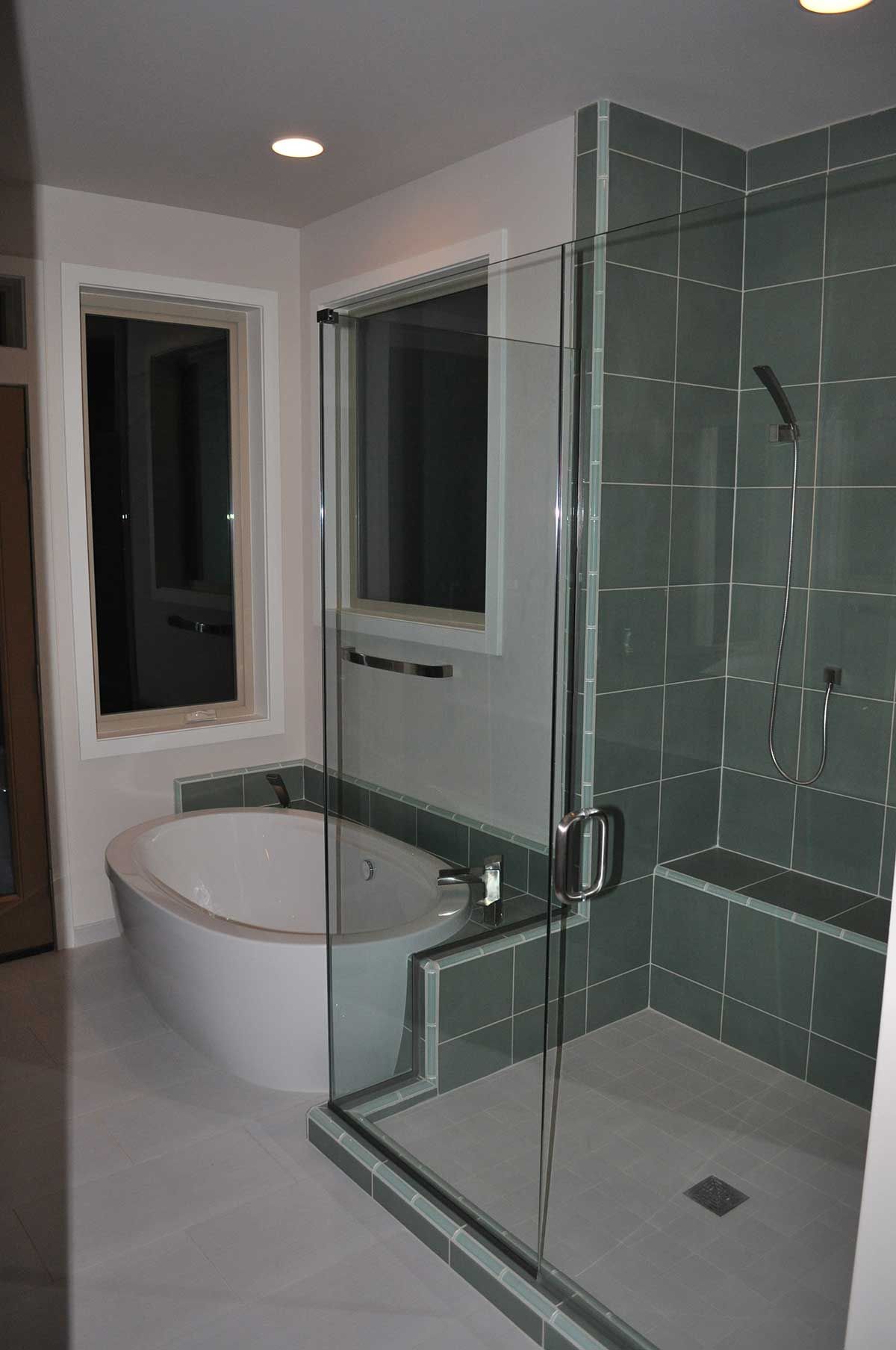 A bathroom with a tub , shower and window