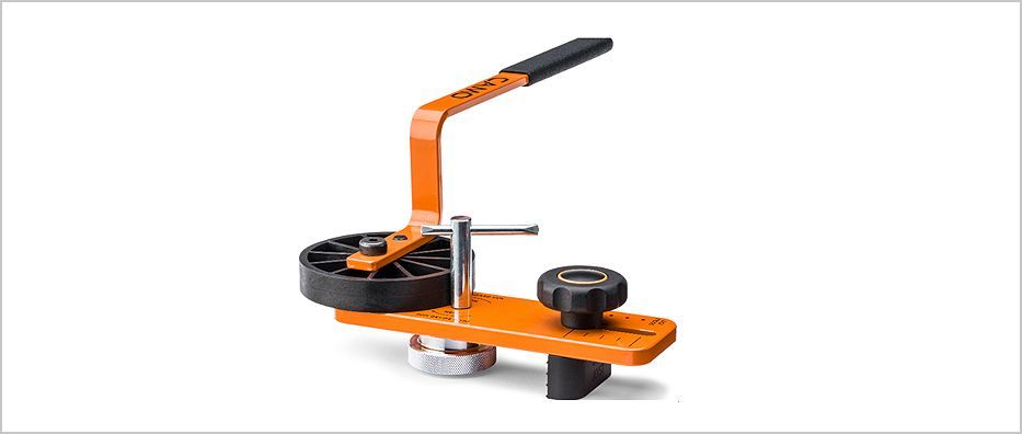 Orange and black hand-crank paper binding machine on a white background