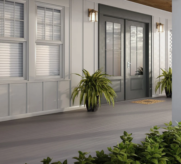Front porch with gray double doors, windows, potted plants, and a gray floor under a covered entry.