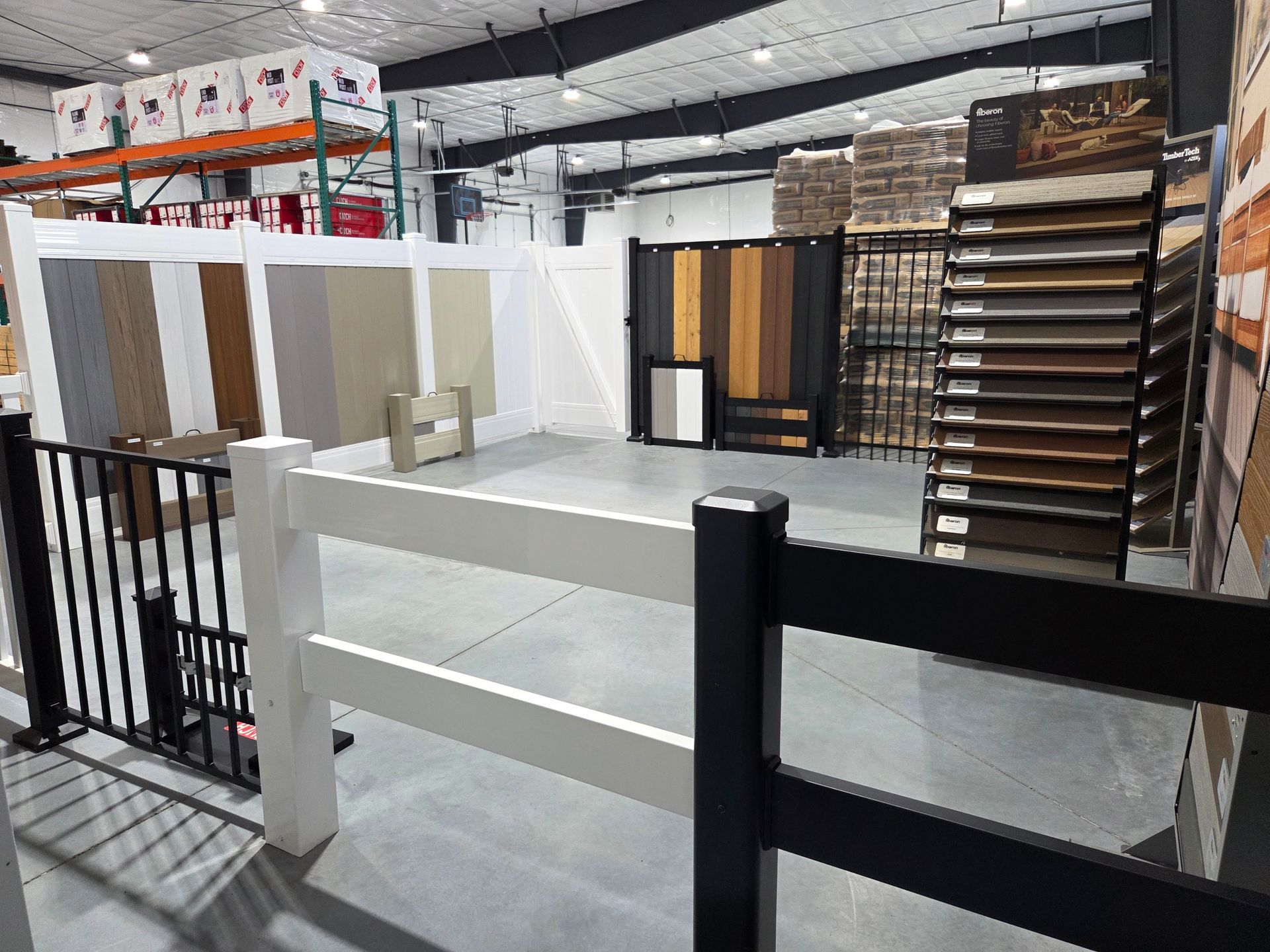 Flooring showroom with display racks of sample planks and panels in a warehouse-like space