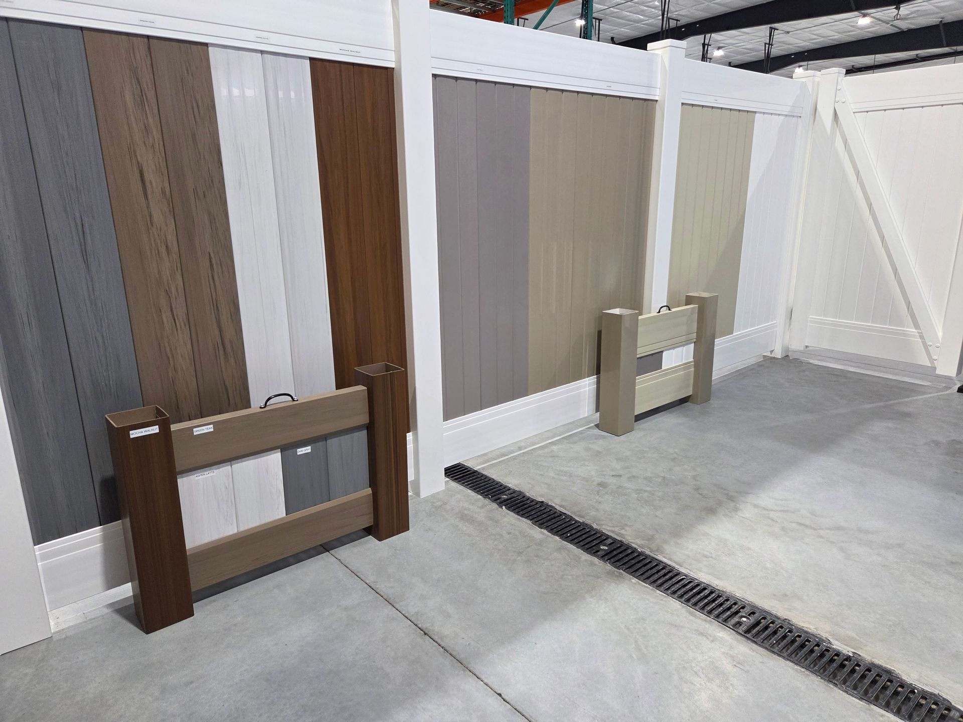 Display of wooden fencing panels and posts in a showroom-like indoor space