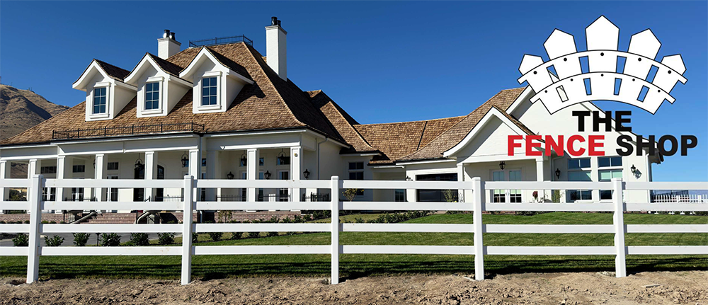 White fence in front of a large house with sign reading “The Fence Shop”