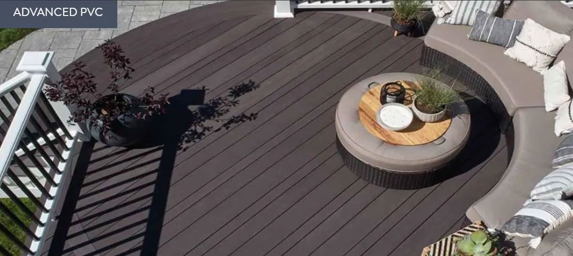 A high-angle view of a curved dark-brown deck featuring a circular seating area with cushions and a center coffee table.