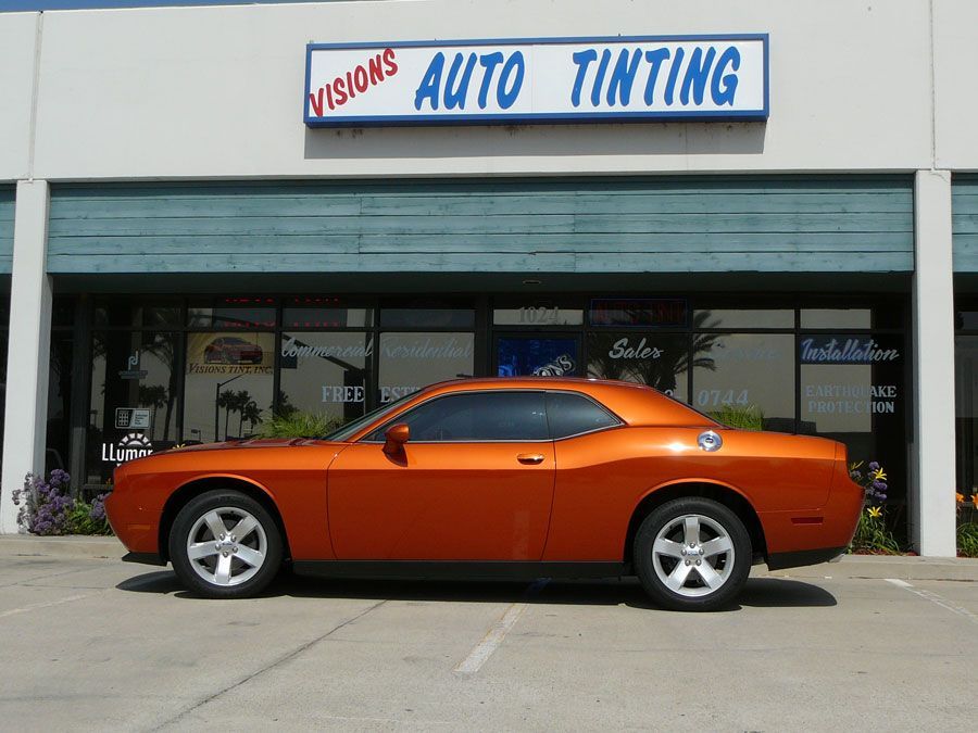 Orange sports car parked outside an auto tinting shop