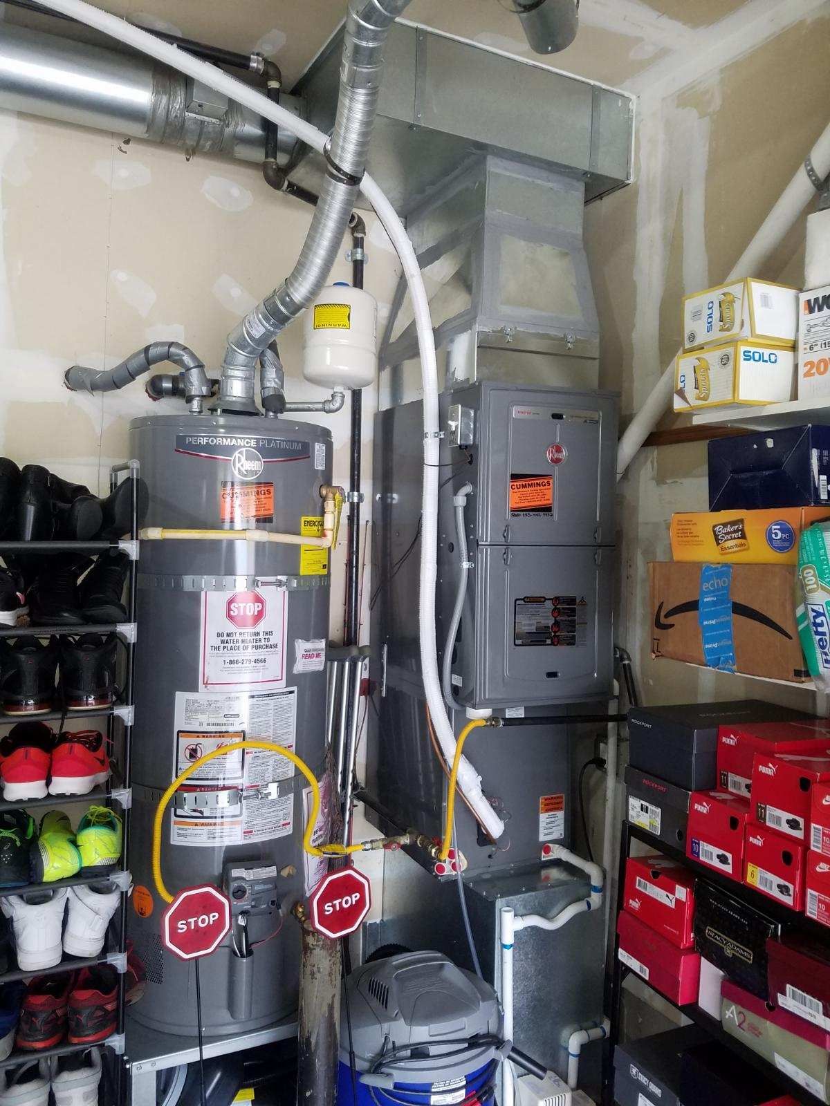 Water heater and furnace in a garage setting, with venting and piping.