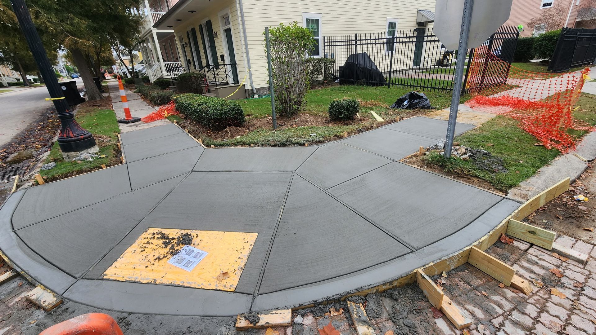 A concrete sidewalk next to a lush green lawn.