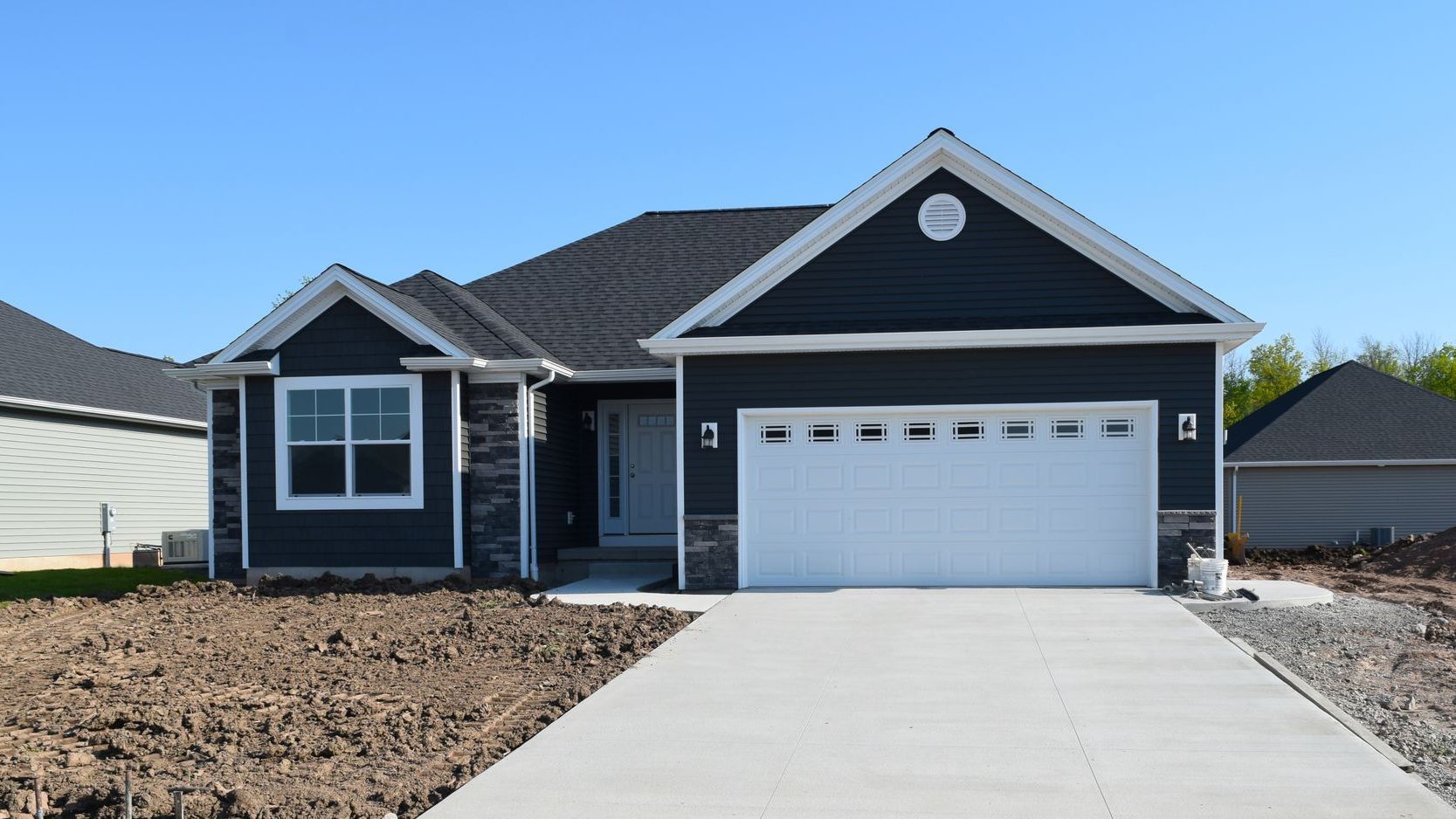 A black and white house with a white garage door