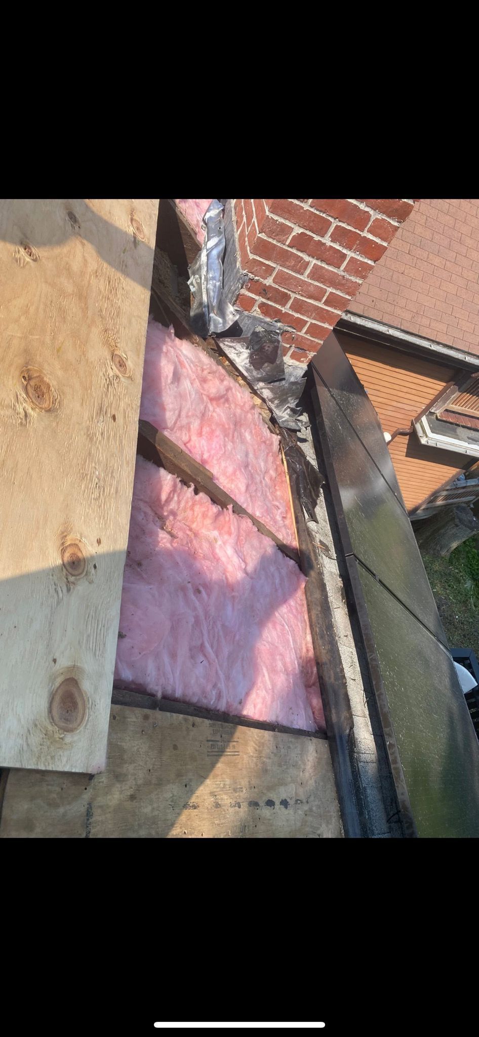 Roof insulation and brick wall. Pink insulation visible.