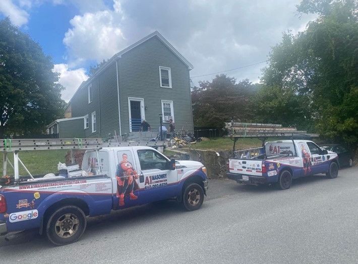Two trucks are parked in front of a house.