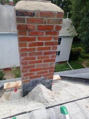 Brick chimney on a rooftop, with visible mortar.