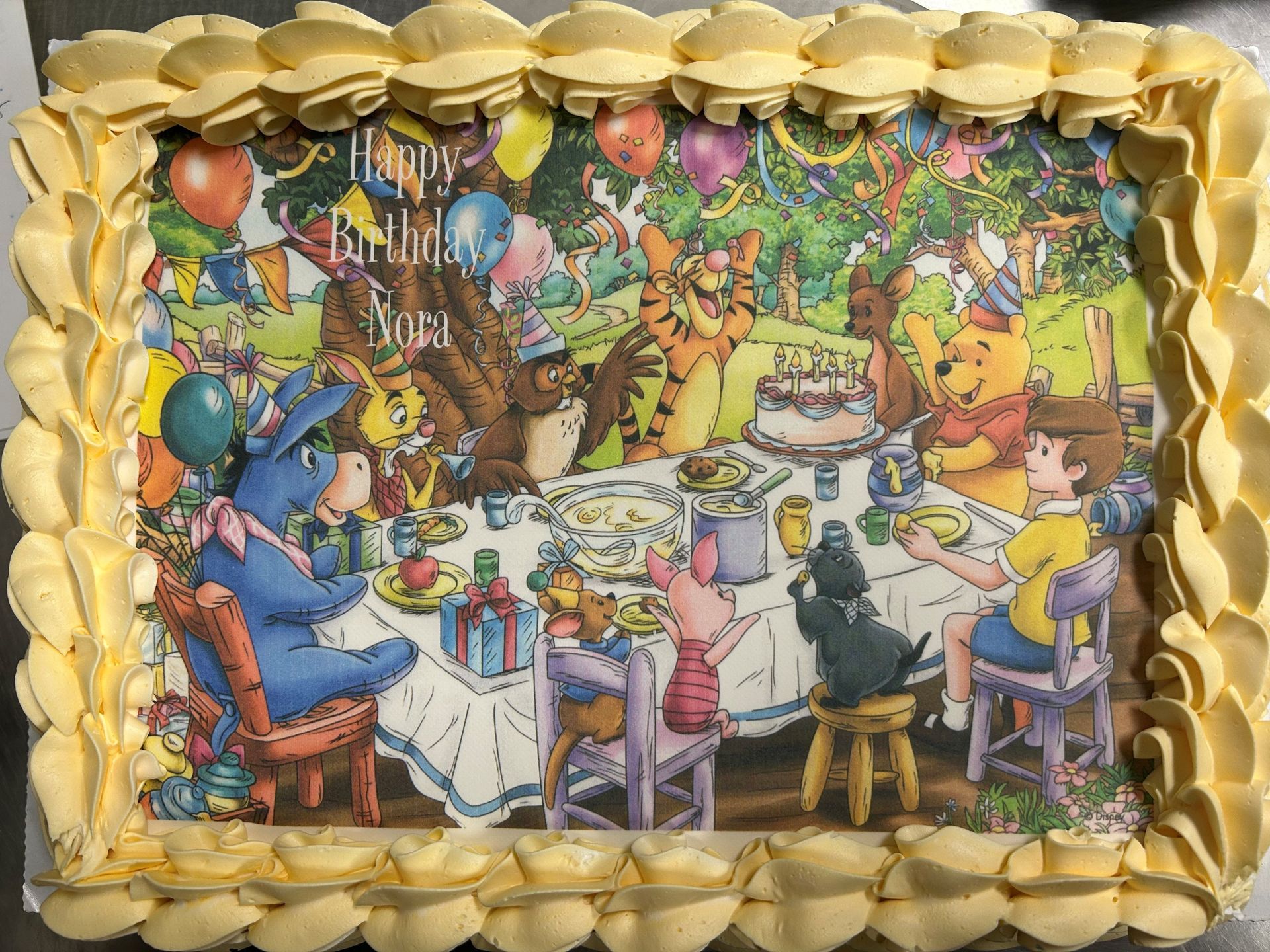 A birthday cake with a picture of Winnie the pooh and friends on it