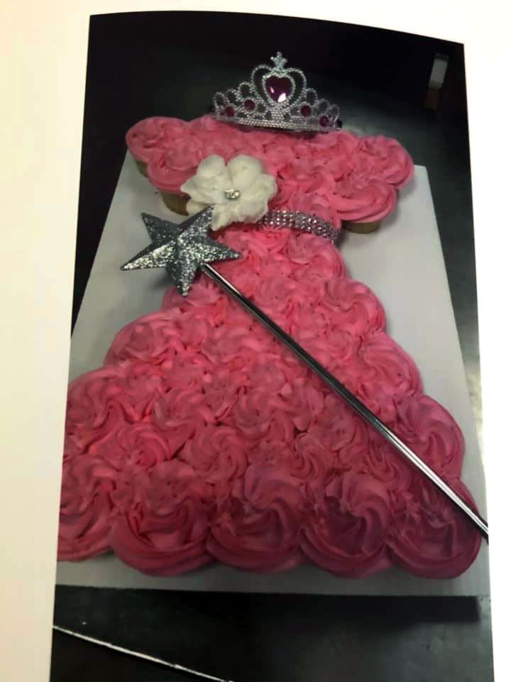 A cake that looks like a dress with a tiara and wand