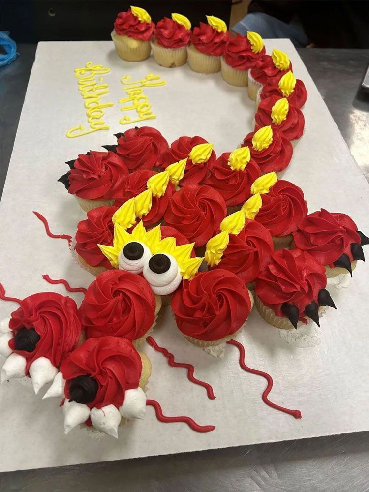 A tray of cupcakes decorated to look like a dragon