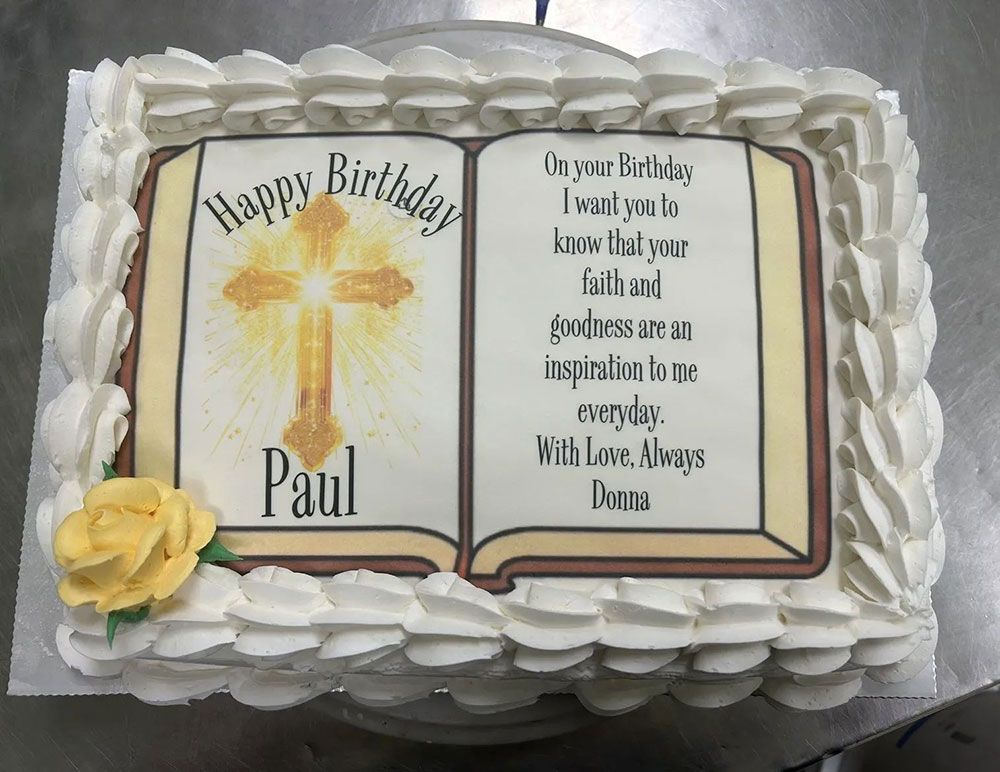 A birthday cake with a bible and a cross on it