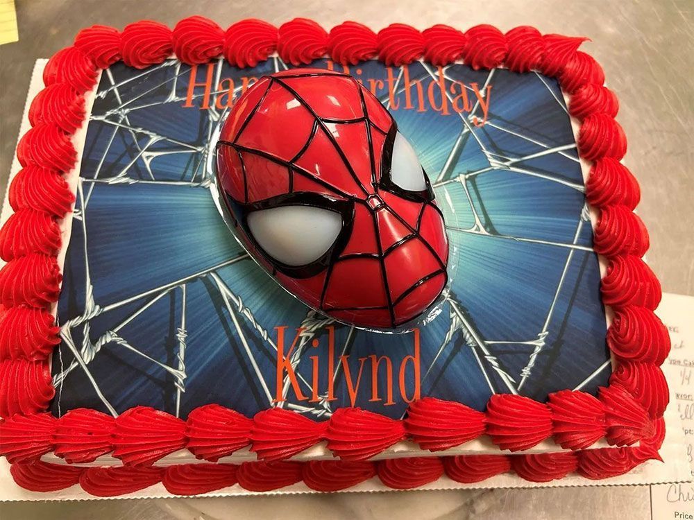 A birthday cake with a picture of spider man on it