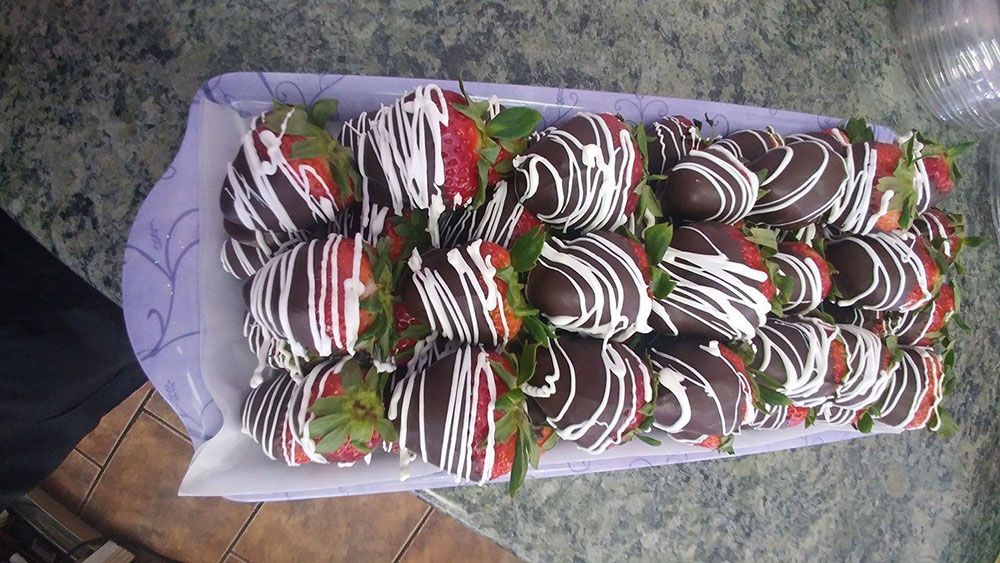 A tray of chocolate covered strawberries on a table