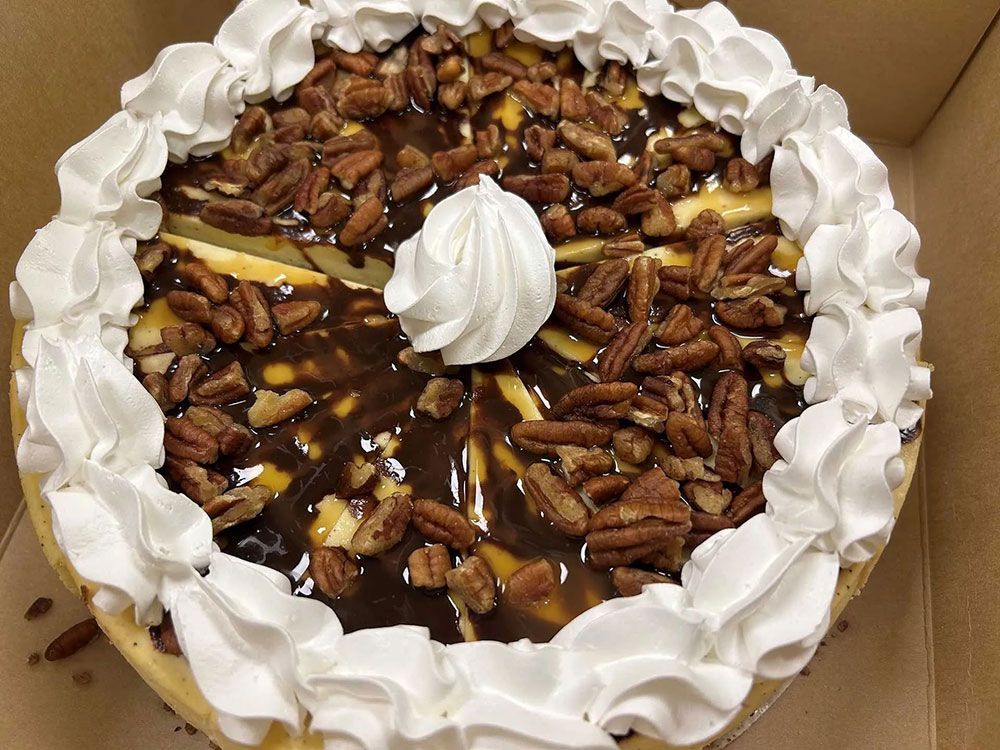 A cheesecake with whipped cream and pecans on top