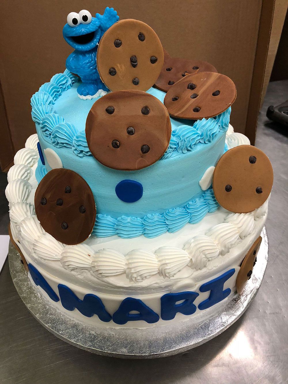 A cake with a cookie monster on top for mari