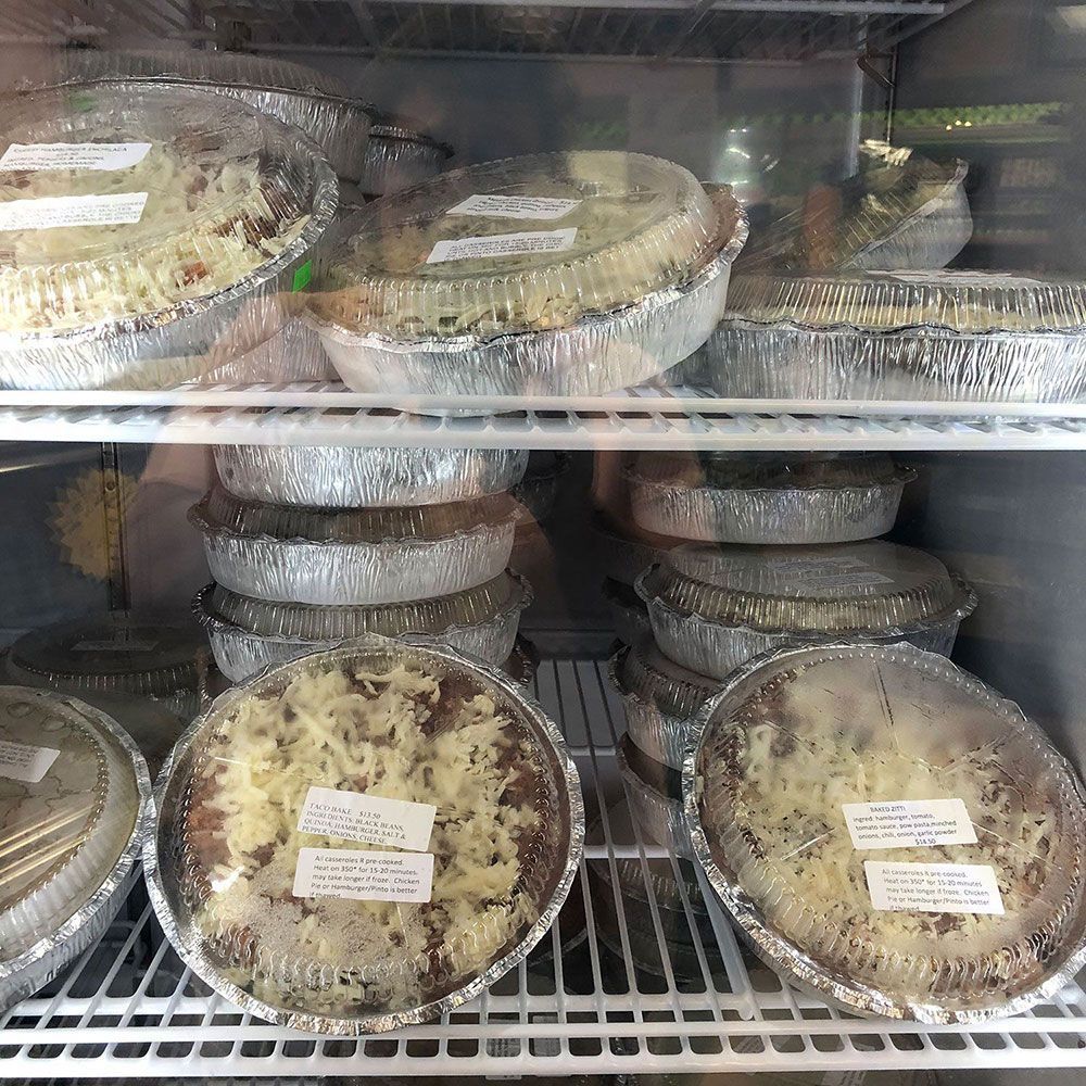 A refrigerator filled with aluminum foil containers of food