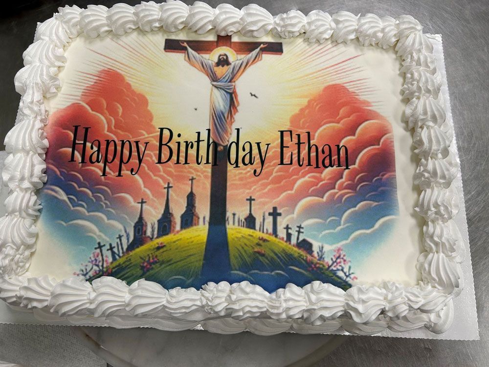 A birthday cake for ethan with a picture of jesus on the cross