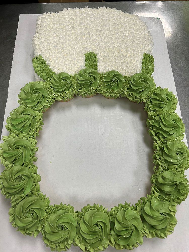 A cake decorated to look like a picture frame is sitting on a table.