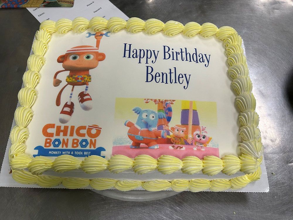 A birthday cake with a picture of chico bon bon on it