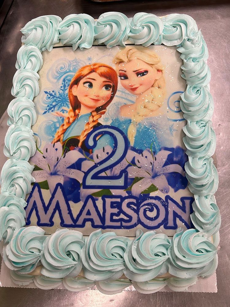 A birthday cake with a picture of anna and elsa on it.