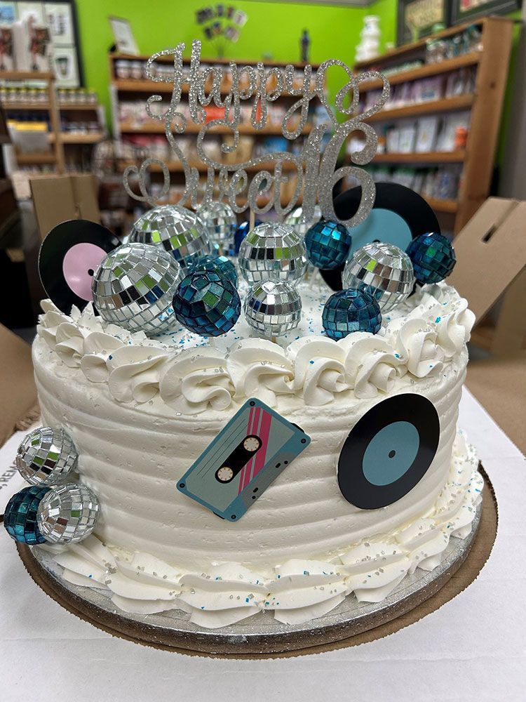 A birthday cake with disco balls and records on it