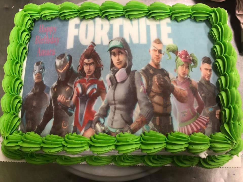 A birthday cake with a picture of fortnite characters on it.