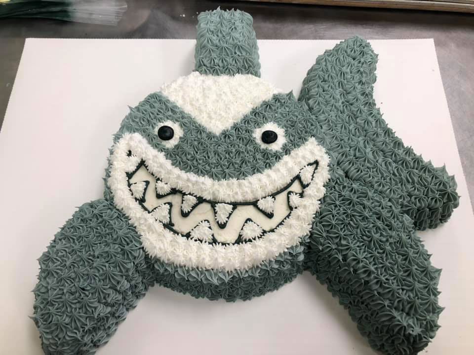 A cake in the shape of a shark with big teeth