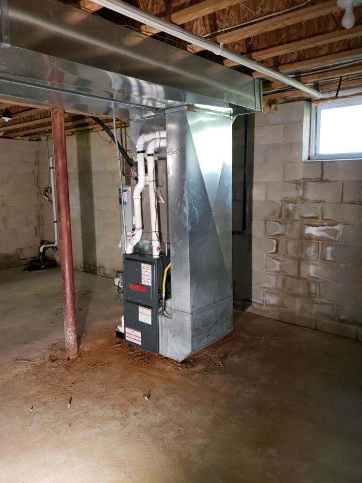 A basement with a furnace and a window.