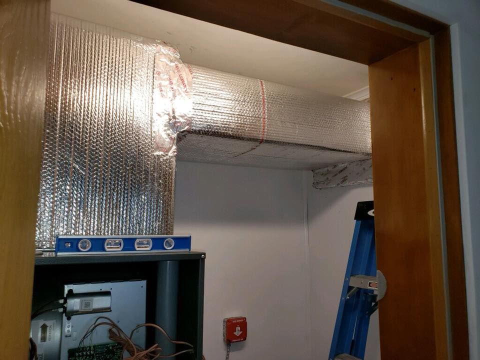 A blue ladder is sitting in a room next to a fire alarm.