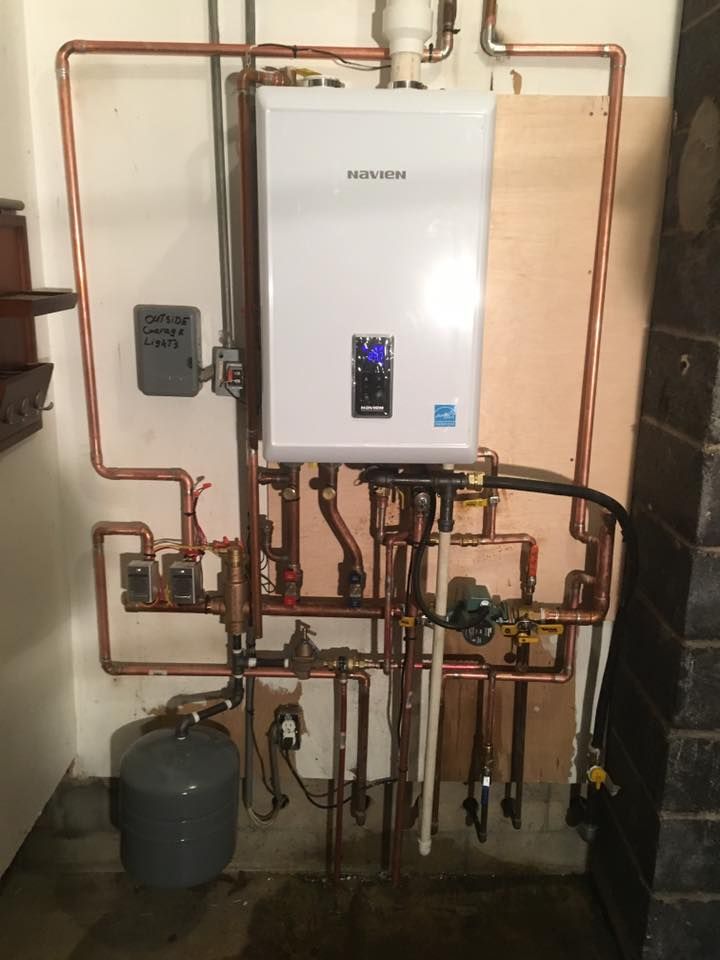 A white water heater with copper pipes attached to it.