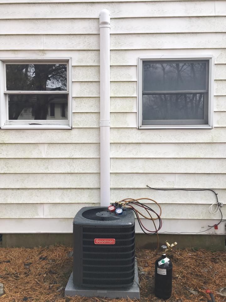 An air conditioner is being installed on the side of a house.