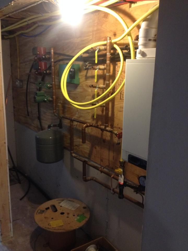 A room with a lot of pipes hanging on the wall.